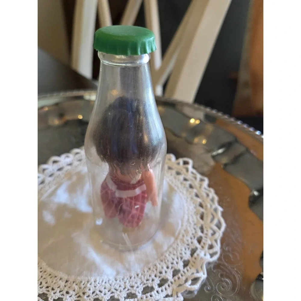 vintage 1960s Cola Kids doll is encased in a clear plastic bottle